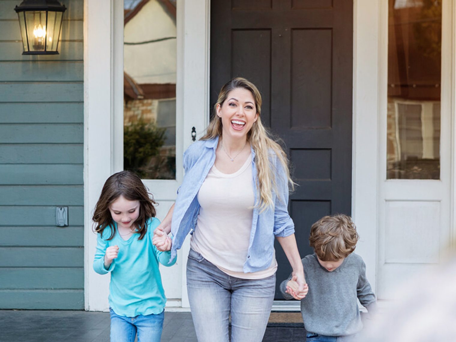 Mother holding her children's hands and smiling.